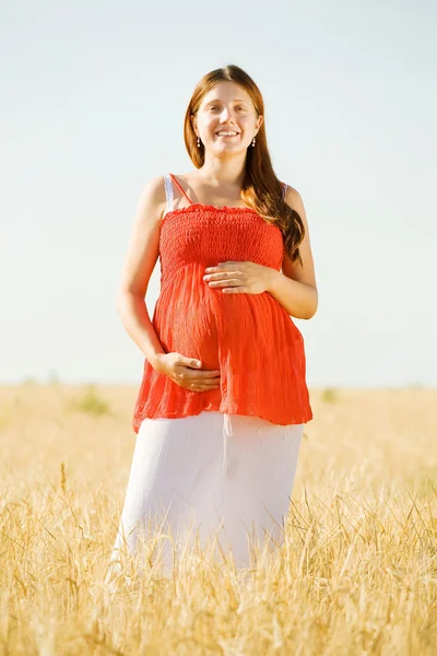 Беременная женщина в летнем поле — стоковое фото