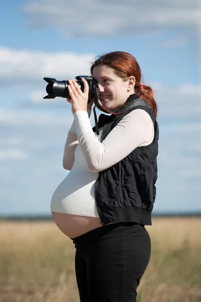 Zwangere vrouw met fotocamera — Stockfoto
