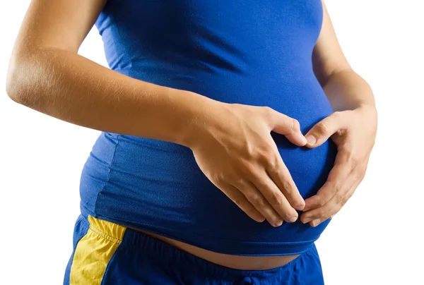 Zwangere buik met hart uit handen — Stockfoto