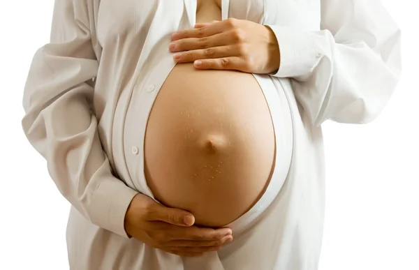 Беременная женщина в белой рубашке — стоковое фото