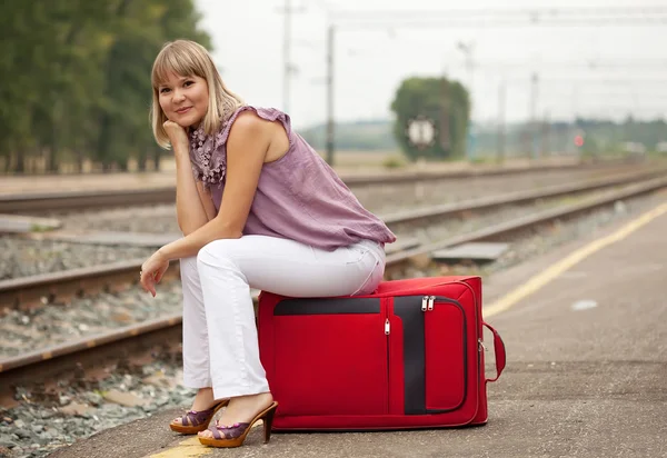 Kvinna med bagage väntar på tåget — Stockfoto