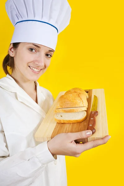 Meisje in chef-kok uniforme houden sneetje brood — Stockfoto