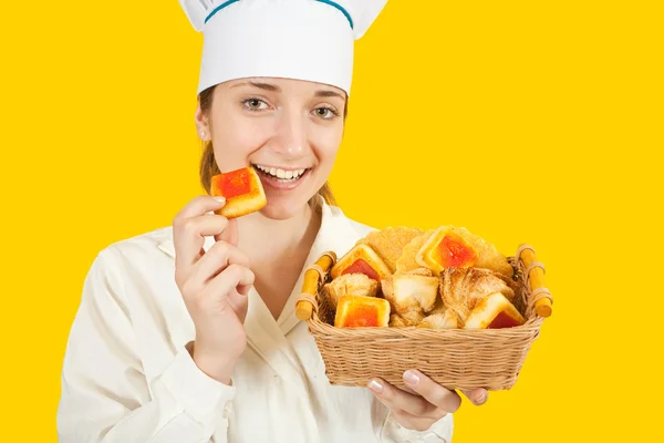Female cook eating tasty cookie — Stock Photo, Image