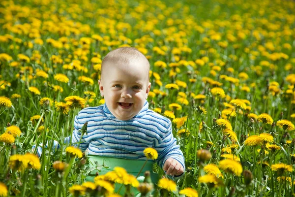 Happy baby in flowers meadow — Stock Photo, Image