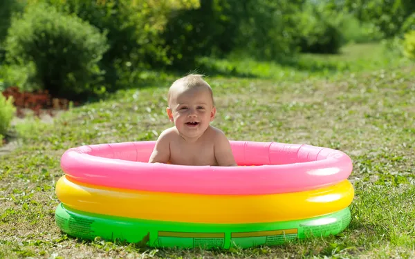 Happy baby swimming in pool — Stock Photo, Image