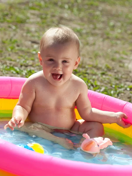 Happy baby swimming in kid inflatable — Stock Photo, Image