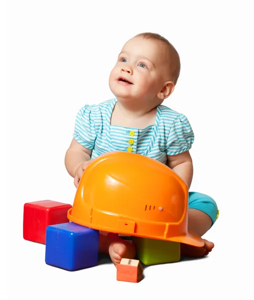 幼児のヘルメットとおもちゃのブロック — ストック写真
