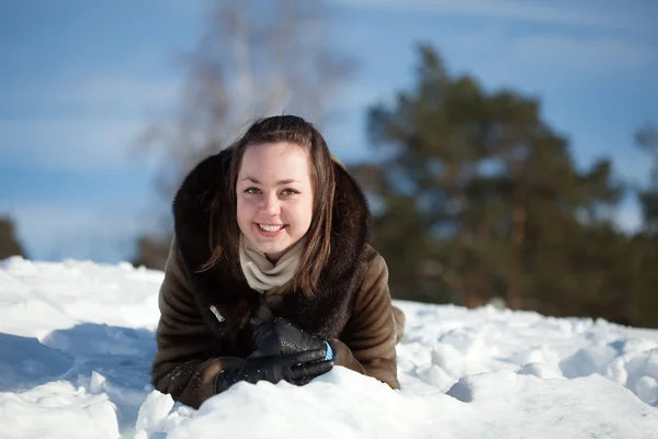Ragazza felice sdraiata sulla neve — Foto Stock