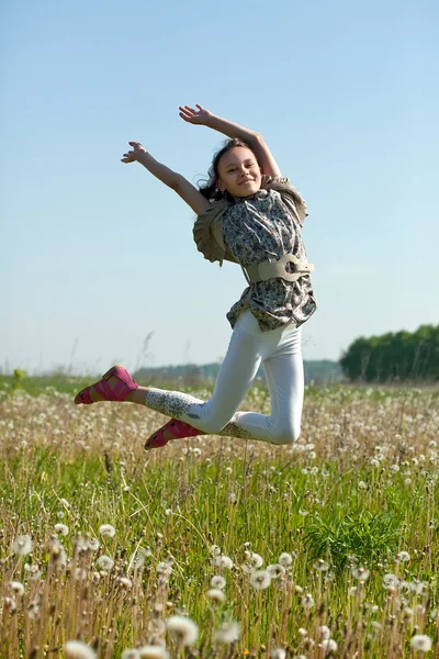 Adolescente menina pula no prado — Fotografia de Stock