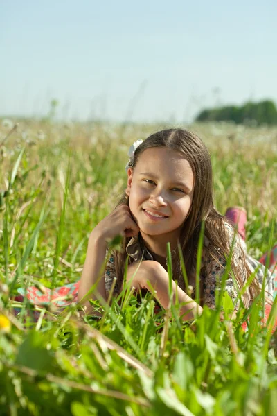 Menina adolescente deitada na grama do prado — Fotografia de Stock