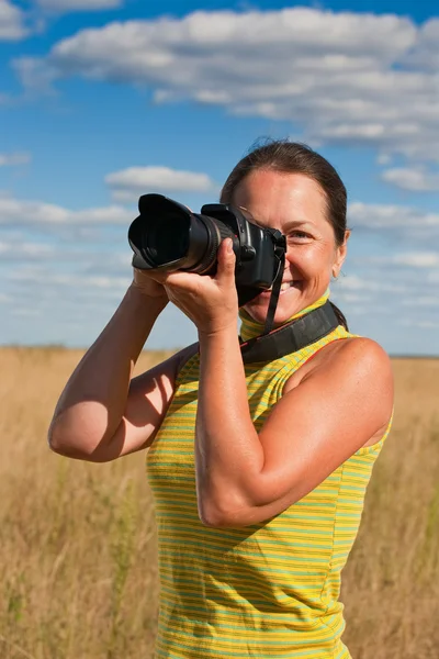 Женщина фотографируется с камерой — стоковое фото
