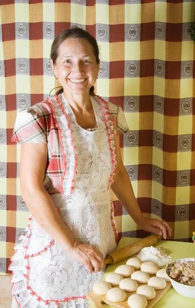 Äldre kvinna matlagning kött pasta — Stockfoto