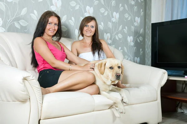 Mujeres con labrador retriever en sofá — Foto de Stock