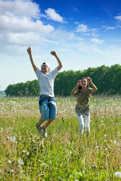 10 代の若者の草原でジャンプ — ストック写真