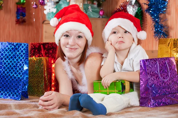 小男孩和母亲在圣诞老人帽子 图库照片