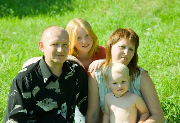 4 가족 잔디에 앉아 — 스톡 사진