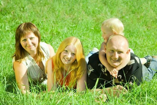 Родители с детьми в траве — стоковое фото