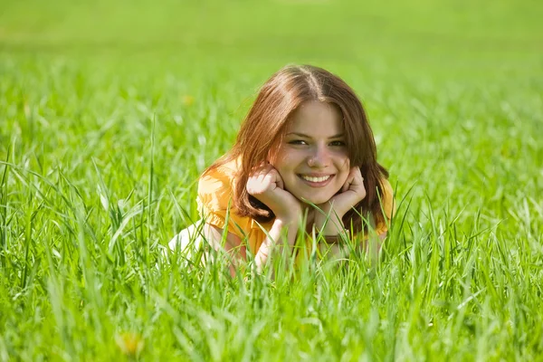 ブルネットの少女の草でリラックス — ストック写真