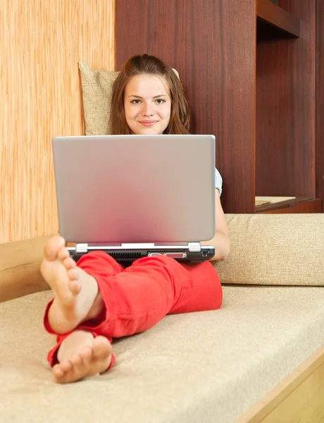 Девушка на диване с ноутбуком — стоковое фото