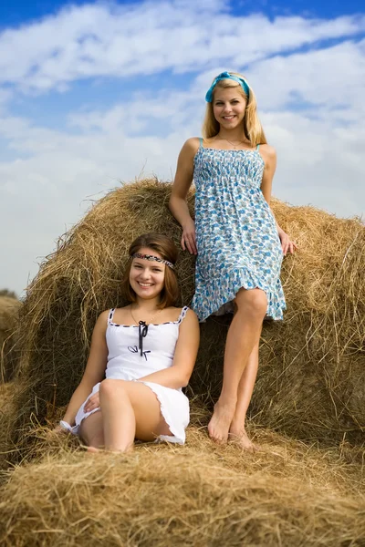 Farm girls resting on hay — Stock Photo, Image