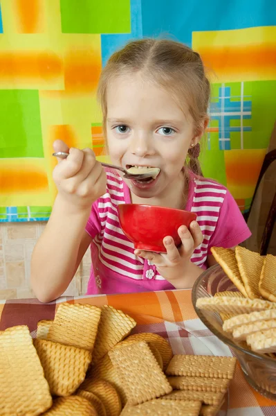 Маленькая девочка ест молочный десерт — стоковое фото