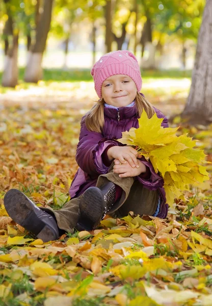 Chica en hojas de otoño amarillo — Foto de Stock