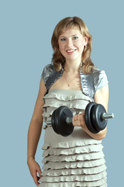 Woman in dress with barbell — Stock Photo, Image