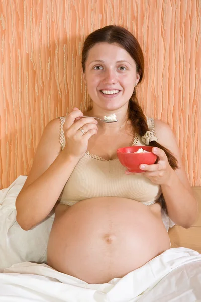 Těhotná žena jíst tvaroh — Stock fotografie