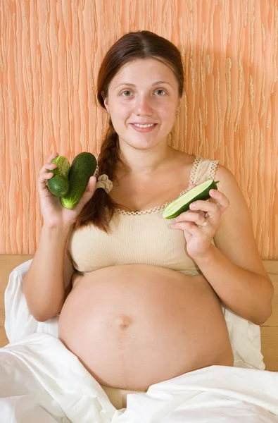 Zwangere vrouw eten komkommer — Stockfoto