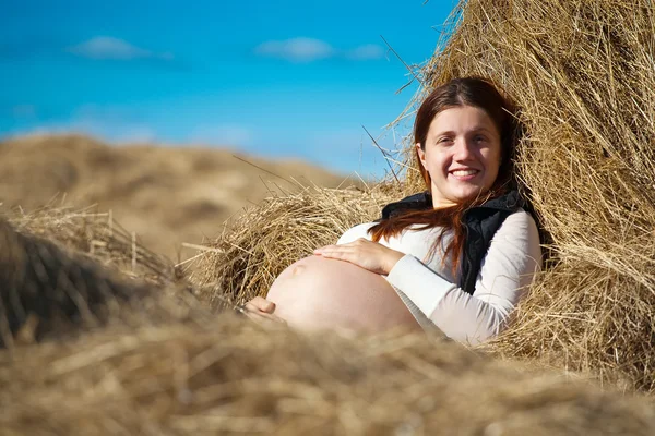 Zwangere vrouw op hooi — Stockfoto