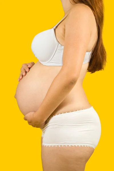 Gravid kvinna över gul — Stockfoto