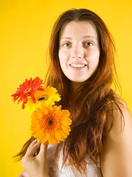 Mädchen mit Blumen über gelb — Stockfoto