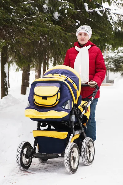 Mother with perambulator in wintery park — Stock Photo, Image