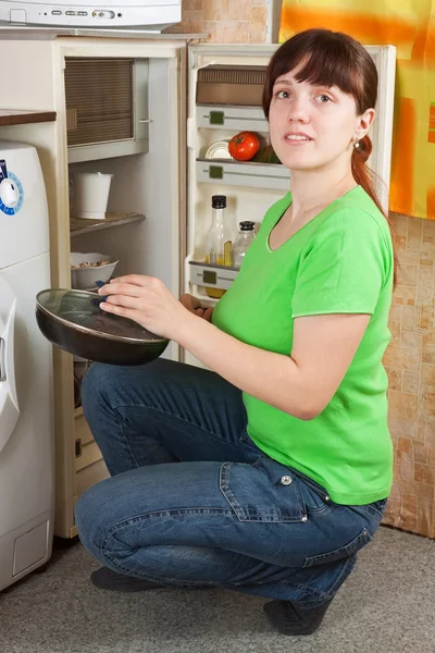 Frau legt Bratpfanne in Kühlschrank — Stockfoto