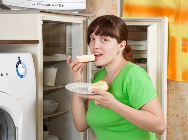 Женщина ест пирог из холодильника — стоковое фото