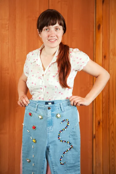 Женщина показывает джинсы ручной работы — стоковое фото