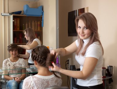 Hair stylist working with girl hair clipart