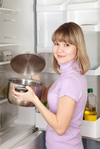 Woman looking into pan from refrigerator — Stock Photo, Image