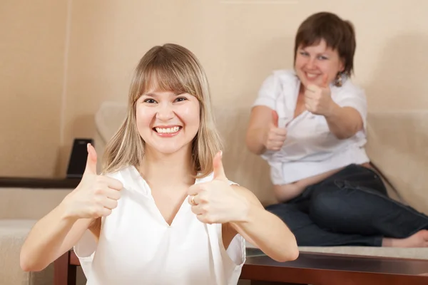 Glada kvinnor visar tummen — Stockfoto