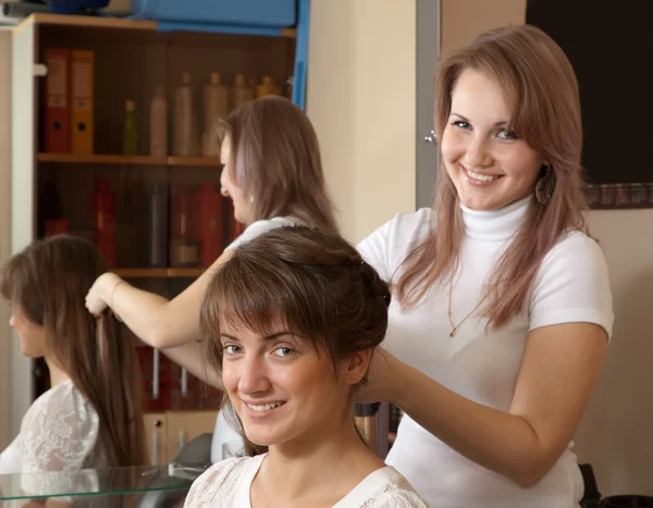 Hair stylist works on woman hair — Stock Photo, Image