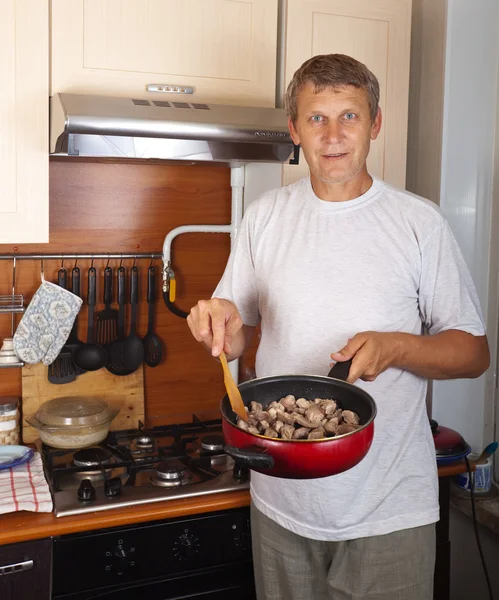 Homem cozinha carne — Fotografia de Stock