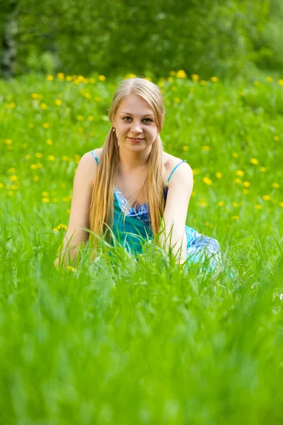 Blonde fille s'assoit dans l'herbe — Photo