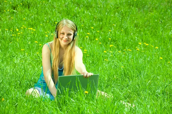Chica en el prado con ordenador portátil —  Fotos de Stock