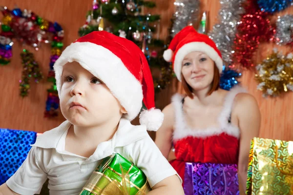 Pojken sitter med julklapp — Stockfoto