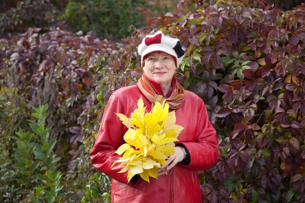 Mature woman with maple posy — Stock Photo, Image
