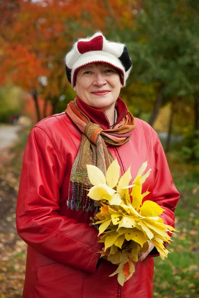 Mature woman in autumn park — Stock Photo, Image