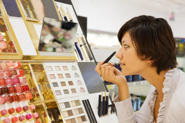 Mulher escolhe o cosmético — Fotografia de Stock