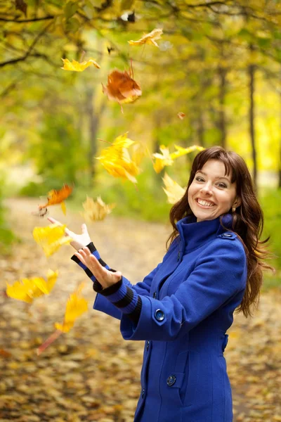 Дівчина викидає кленові листя — стокове фото