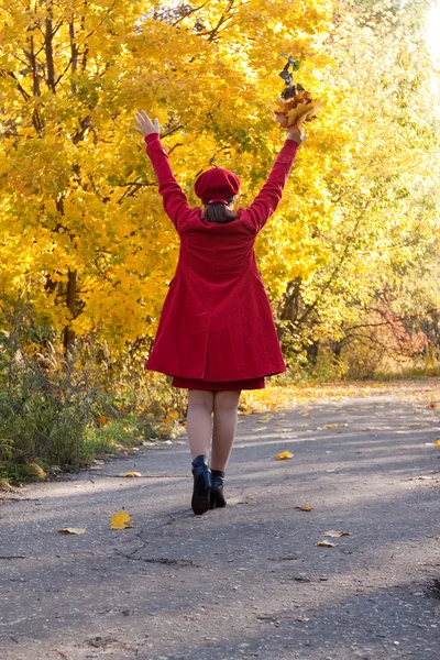 Ходячая счастливая женщина осенью — стоковое фото