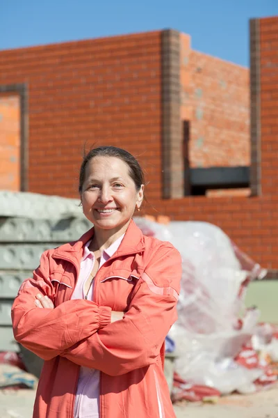 Konut inşa karşı mutlu bir kadın — Stok fotoğraf